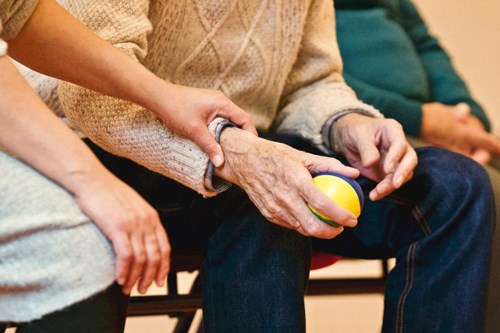 A close up of a group of elderly people playing a seated ball game
