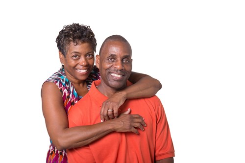 A woman smiling with her arms wrapped around a man's shoulders