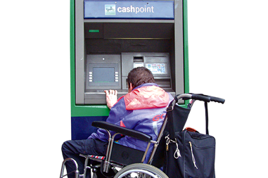 A person in a wheelchair using a cash point.