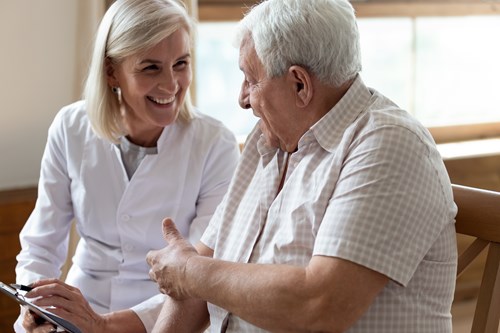 Older man talking and smiling with a health professional